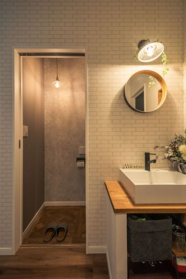 照明や壁紙、洗面台をセンス良く採り入れた玄関ホールの「トイレ＆手洗いスペース」